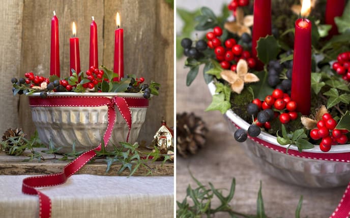 Ein selbst gemachter Adventkranz in der Gugelhupfform mit roten Kerzen und winterlichen Beerenfrüchten.