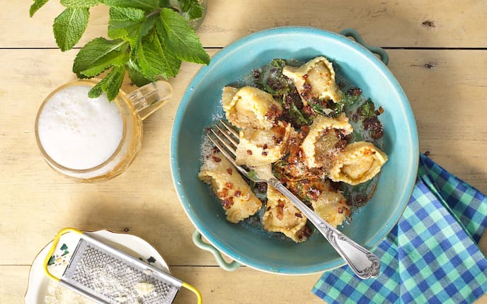 Nudeln mit Schweinefleisch und Minze gefüllt, Parmesan, Serviette, Bier